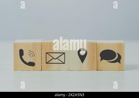 wooden cube block icon letter telephone location on table.Business communication and social network concept. Stock Photo