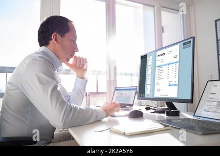 Accountant Using E Invoice Software At Computer Stock Photo