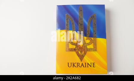 Ukraine flag and coat of arms. Golden trident on cloth flag. National symbol. Blue-yellow flag of Ukraine. Stock Photo