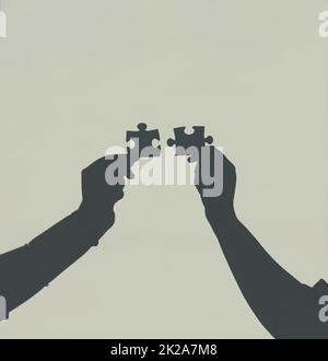 Finding that perfect fit. Defocussed shot of two unrecognizable businesspeople holding two puzzle pieces together. Stock Photo