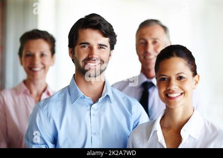 We are a great team. A group of corporate co workers standing alongside each other. Stock Photo
