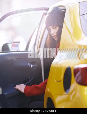 On the move in the city. Portrait of a fashionable young woman getting into a cab in the city. Stock Photo