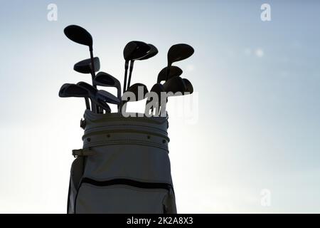 Tools for the professional golfer. Silhouette of a golf bag with the sky in the background. Stock Photo