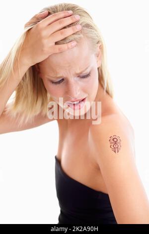 Bold beauty. Studio shot of a beautiful young woman with a tattoo on her shoulder against a white background. Stock Photo