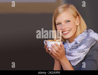 Its the elixir of life. Portrait of a young woman drinking coffee in a cafe. Stock Photo