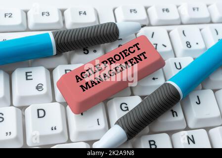 Hand writing sign Agile Project Management. Concept meaning management methodology from traditional to modern technology Downloading Online Files And Data, Uploading Programming Codes Stock Photo