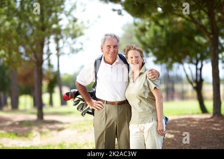 Golf - A sport that brings us closer together. Portrait of a mature and happy couple embracing during a game of golf. Stock Photo