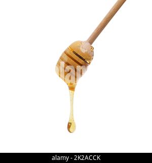 Dripping with bee juice. Shot of a honey dipper dripping delicious honey. Stock Photo