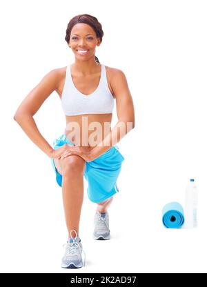 Stretching those muscles. Young african american woman stretching against a white background. Stock Photo