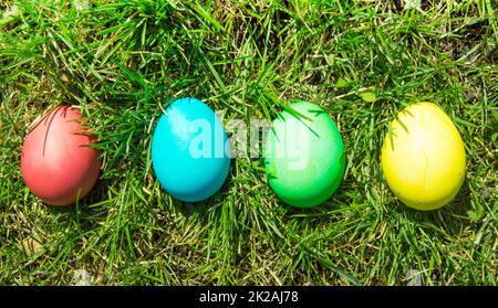 Four painted and decorative Easter eggs in the grass. Top view, copy space Stock Photo