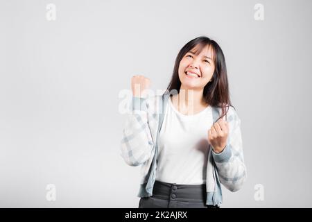 Smiling happy woman makes raised fists up celebrating her winning success gesture Stock Photo
