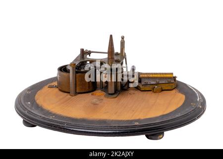 Inside the antique revolving Christmas tree stand the mechanism for playing two Christmas carols consisting of roller mechanism with music box and spring drive. Clipping path. Stock Photo