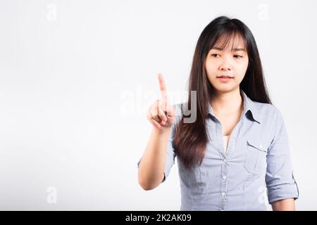 Woman standing her smile confidence with touching an imaginary screen with her finger Stock Photo