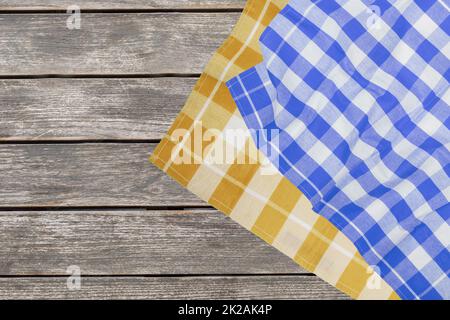 Empty table product. Top view of a rustic wooden table with a blue and a yellow checked tablecloth or napkin. Template for your food and product presentation montage. Space for food recipes. Stock Photo