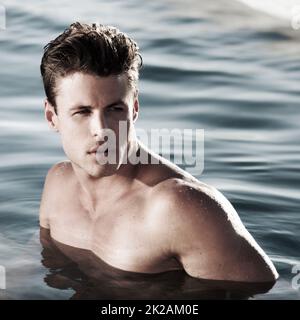 A moment to myself. A handsome male model in water looking to the side. Stock Photo