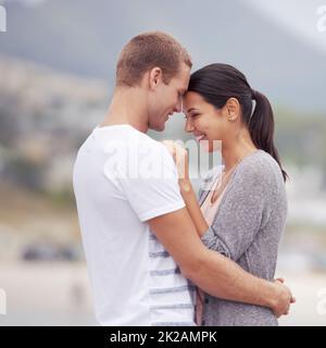 So in love. Shot of an affectionate young couple at the beach. Stock Photo