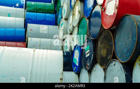 Old chemical barrels. Hazard chemical barrel with warning label. Steel tank of flammable liquid. Empty steel oil tank. Toxic waste warehouse. Hazard waste storage in factory. Metal brent oil drum. Stock Photo