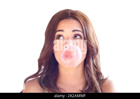 Blowing bubbles. An attractive young woman blow bubbles with gum. Stock Photo