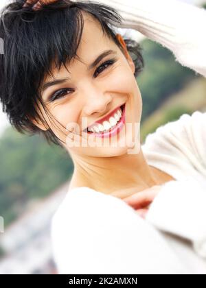 Stunning and all natural. Closeup portrait of a beautiful young woman smiling at the camera. Stock Photo
