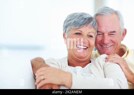 Smiling mature couple relaxing at home. Portrait of smiling mature couple spending time together at home. Stock Photo