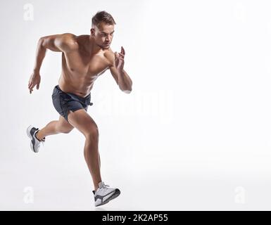 Take a step forward into your fitness journey. Shot of an athletic young man against a white background. Stock Photo