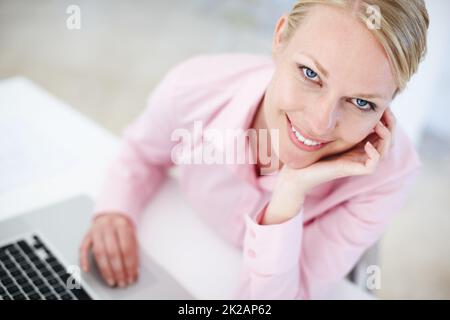 All set to run her new business from home. Portrait of a young blond woman sitting at her desk with a laptop. Stock Photo