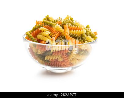 Three colors fusilli pasta in bowl. Colorful italian raw pasta isolated on white background. Stock Photo