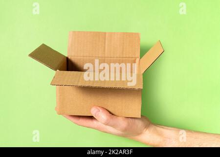Hand holding open brown paper box Stock Photo