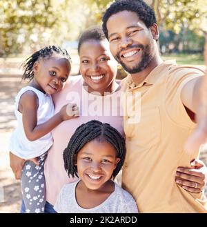 Happy black family take a selfie in nature on a holiday vacation trip together enjoy quality time at a kids park. Smile, happiness and African girls