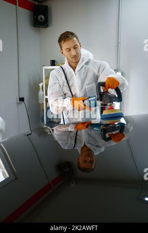 Professional car service worker polishing painted surface Stock Photo