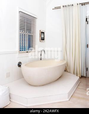 Step into modern luxury. Beautiful white bathtub in the corner of a stylish bathroom. Stock Photo