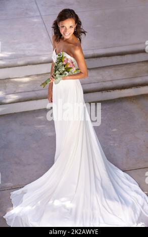 Shes a beautiful bride. Beautiful young bride holding her bouquet. Stock Photo