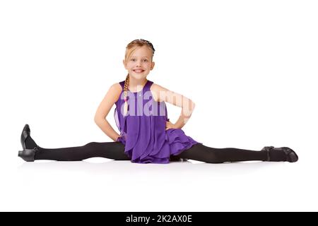 Ta-daa. Full length shot of a young girl doing the splits isolated on white. Stock Photo