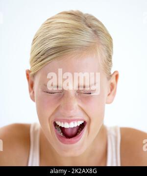 Venting her emotions. A frightened young woman shrieking with her eyes closed. Stock Photo