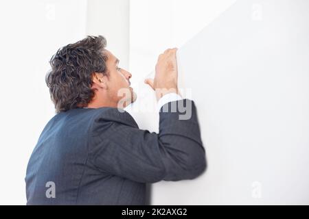 Man peeking over wall. Smart business man peeking over the wall. Stock Photo
