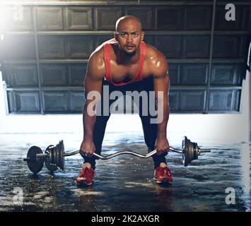 Hes a beast. Full length portrait of a muscular young man lifting weights. Stock Photo