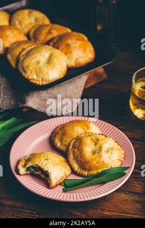 Freshly Baked Hand Pies Filled with Chives and Mushrooms. One Pie with Bite Taken Out of It Stock Photo