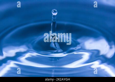 Wallpaper of drop falling on water and making ripples Stock Photo