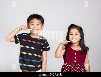 Little cute kid boy and girl 3-6 years old brushing teeth and smile in studio shot isolated Stock Photo