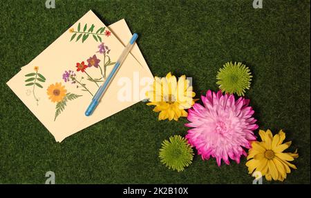Flowers on Artificial Grass With Blank Greeting Card Decorated With Dried Flowers Stock Photo