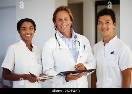 Using technology for a healthier tomorrow. Portrait of three medical professionals working with a digital tablet. Stock Photo