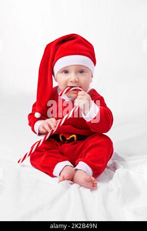 The biggest gift of all. Studio shot of a little boy dressed up in a santa costume. Stock Photo