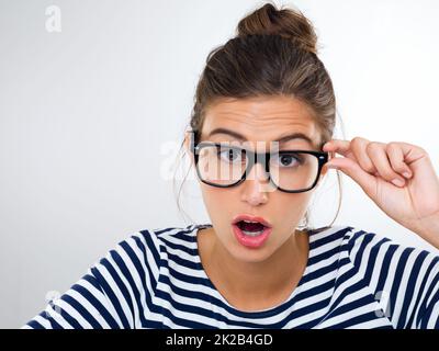 I cant believe my eyes. Studio shot of a gorgeous young woman wearing glasses. Stock Photo