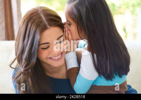 Can I tell you a secret. Little girl whispering a secret to her mom. Stock Photo
