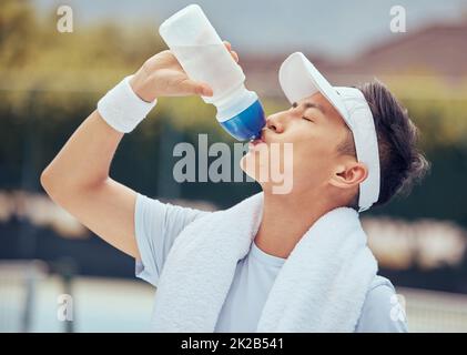 Asian man drinking water, fitness and relax after a training session, workout or exercise. Athlete, health and sports male resting with refreshing Stock Photo