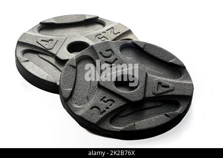 Two black metal pancakes of 2.5 kg each lie on a white isolated background Stock Photo