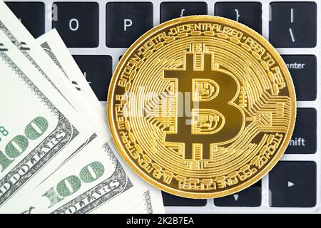 Golden Bitcoins coin and  US banknotes on keyboard computer Stock Photo