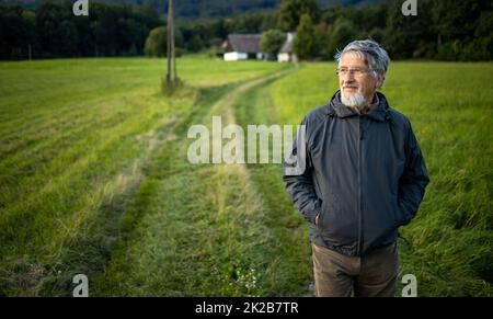 Senior man enjoying the outdoors, hiking, walking through lovely nature Stock Photo