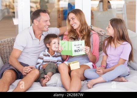 Worlds best mom. Happy young family of four celebrating mothers day. Stock Photo