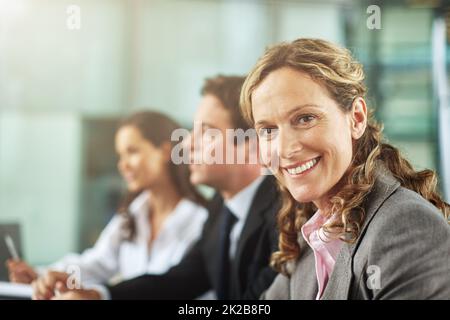 Im loving this presentation. Cropped shot of three businesspeople sitting behind a desk during a presentation. Stock Photo